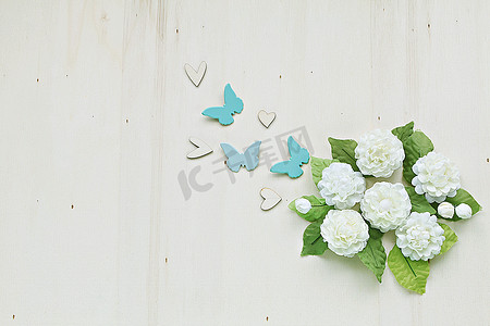 茉莉鲜花摄影照片_木背景中手工制作的茉莉花、心形和蝴蝶