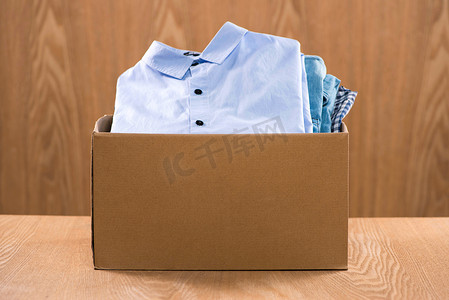 志愿者用木制背景上的食物捐赠箱Volunteer with donation box with foodstuffs on wooden background