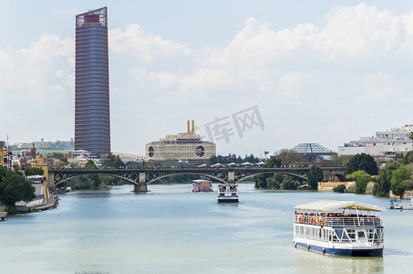 水瓜摄影照片_瓜达尔基维尔河，塞维利亚塔，特里亚纳桥，塞维利亚，西班牙