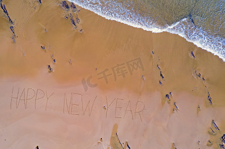 年末送壕礼摄影照片_从海浪中拍摄的空中顶部和手写的新年快乐