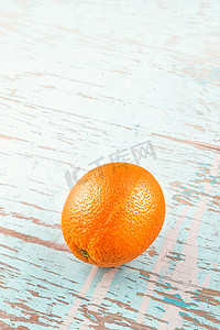 质朴的蓝木背景上的新鲜成熟甜橙水果