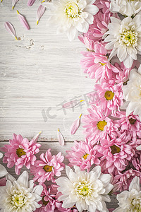 粉色花花背景摄影照片_垂直白色木桌上的白色和粉色花框