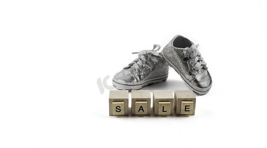 .Sale Concept - 儿童闪闪发光的小运动鞋在木制立方体上
