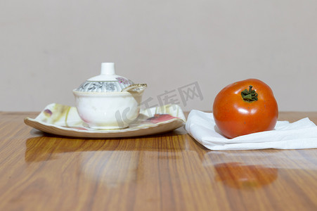 木制餐桌上的番茄和碟子。