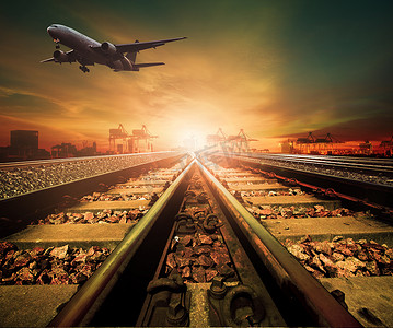 飞行轨道摄影照片_铁路和货机在物流船港口上空飞行的轨道