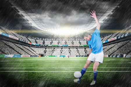螺距摄影照片_橄榄球运动员踢橄榄球的合成图像