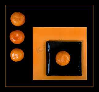橙色普通话和黑色方形盘子在橙色桌子上的组成。