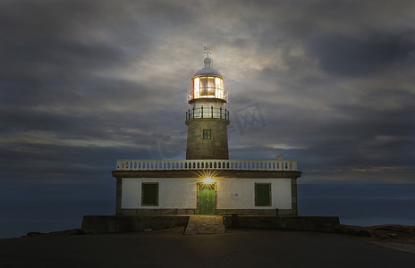 大海黄昏摄影照片_Corrubedo 灯塔，西班牙在黄昏照亮