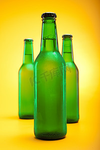 冰镇啤酒摄影照片_黄色背景中的冰镇啤酒
