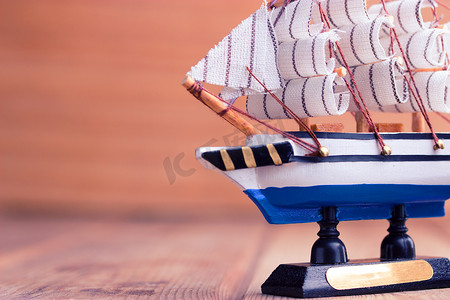 木制背景上的玩具帆船