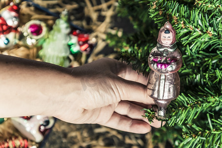 Hand hanging up his on the Christmas tree 圣诞树装饰