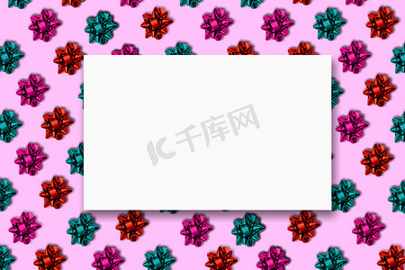蝴蝶结边框摄影照片_粉红色背景上彩色包装蝴蝶结的无缝边框条纹。
