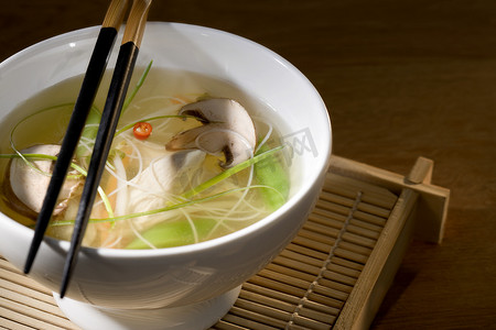 用筷子在碗里加蔬菜的鸡汤