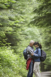 一对中年夫妇在林道上拥抱的侧视图