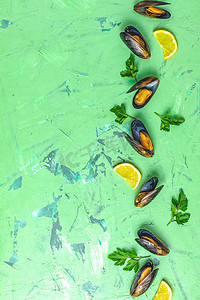 绿色混凝土桌上的海鲜贻贝配柠檬和欧芹