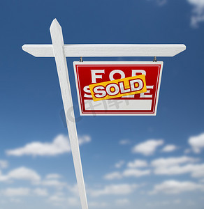 正对着出售的房地产标志在蓝天白云上。