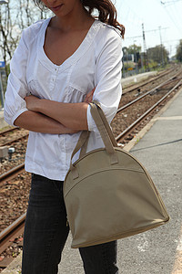牛仔裤的线摄影照片_等火车的女人