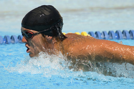 男运动员在游泳池中比赛的侧视图