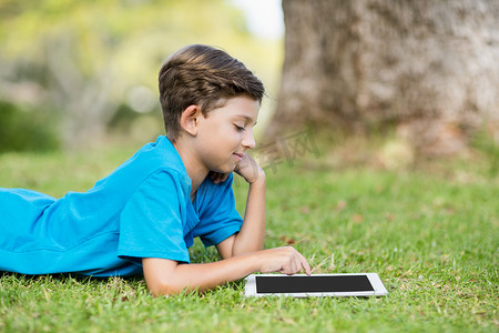 在公园里使用数字平板电脑的小男孩