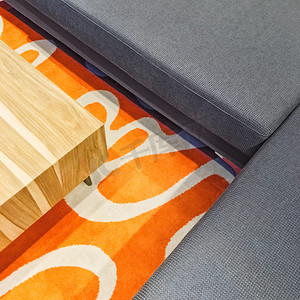 灰色转角沙发和橙色地毯