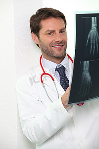 手部x光片摄影照片_医院医生检查某人手部的 X 光片