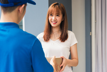 穿制服的送货员快递员拿着包裹邮箱服务装运女顾客