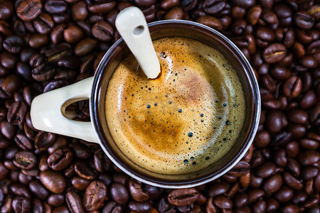 咖啡豆红色摄影照片_红色背景中带烤咖啡豆的咖啡杯，咖啡 c