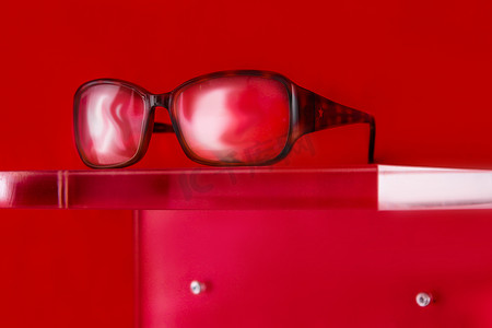 红色背景有机玻璃显示器上的眼镜