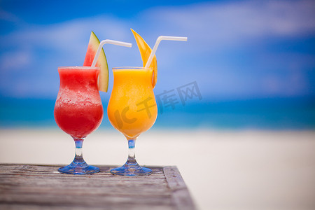 令人惊叹的绿松石海背景中的两杯鸡尾酒新鲜西瓜和芒果