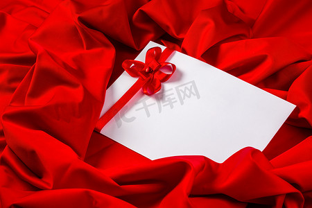 红色织物上带有心形和丝带的爱心卡片