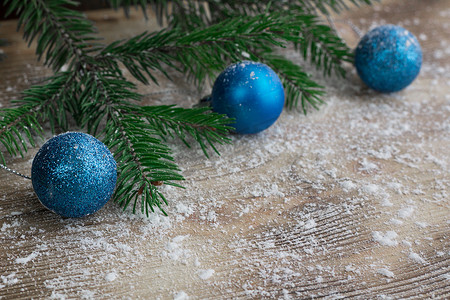 势利的摄影照片_圣诞树枝，蓝色球在冬天积雪的木 b