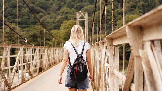 美丽的女孩旅行，走在桥上