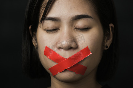 自由平等摄影照片_亚洲女性眼罩用红色胶带包嘴