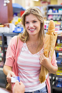 超市收银台摄影照片_在收银台微笑的女人用信用卡付款