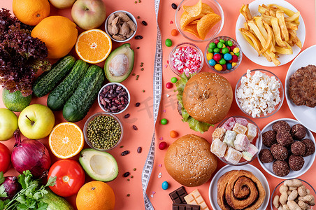 橙色背景中的水果和蔬菜与糖果和快餐顶视图平面
