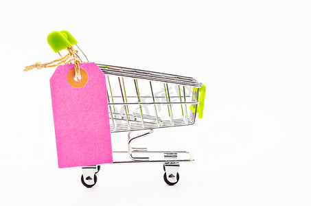 超市标签摄影照片_与购物车的空白的桃红色纸价牌。
