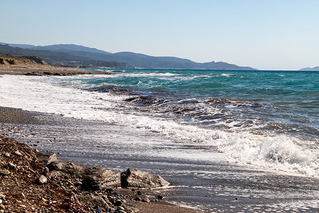 从希腊罗得岛西侧的卵石滩和水浪看海岸线