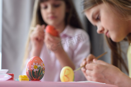 孩子们画复活节彩蛋，专注于他们面前的彩蛋