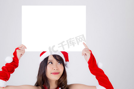 拿着空白板的美丽的年轻亚裔圣诞老人妇女为圣诞节我