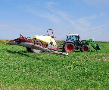 农业喷雾器摄影照片_带喷雾器的拖拉机在田间