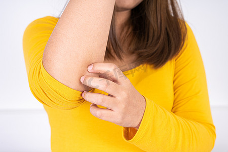 疼痛广告摄影照片_女性用复制空间在白色背景上抓她的手臂。