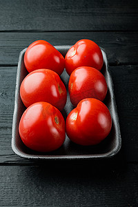 红色成熟的西红柿，在黑木桌上