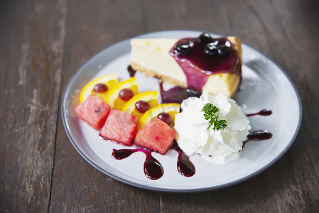 色彩缤纷的纽约芝士蛋糕，配有装饰精美的水果片和白盘生奶油 — 蛋糕食谱菜单概念