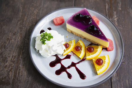 精美菜单摄影照片_五颜六色的芝士蛋糕蓝莓配上装饰精美的水果片和白盘中的鲜奶油 — 蛋糕食谱菜单概念