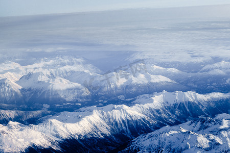 蓝色的直升飞机摄影照片_加拿大不列颠哥伦比亚省白雪皑皑的山峰鸟瞰图
