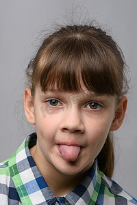 一个十岁女孩吐舌头的肖像，欧洲人的外表，特写