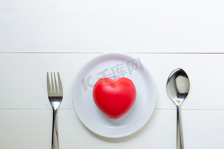 红色叉摄影照片_红色的心与爱和盘子和勺子和叉子在木背上