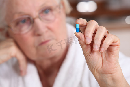 一位老妇人正在服药。