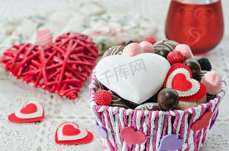 篮子里的饼干摄影照片_篮子里放着巧克力、饼干和装饰性的情人节红心