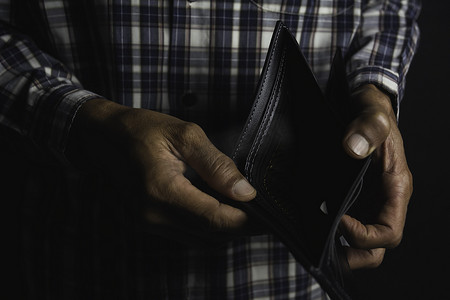 一个男人站着拿着空钱包的特写镜头。